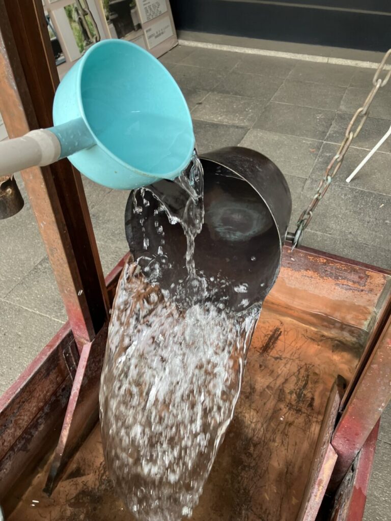 突然傾いて水がこぼれ出す器の写真